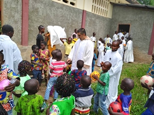 Father Yovane Cox with parishioners in DRC before conflict smaller